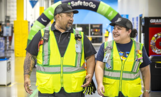 Amazon employees wearing safety vests at a facility